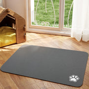 Tapis de repas Nidofé Rive gris, avec motif de patte, posé sur un sol en bois.