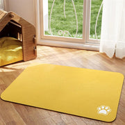 Tapis de repas Nidofé Rive jaune, avec motif de patte, posé sur un sol en bois.