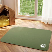 Tapis de repas Nidofé Rive vert olive, avec motif de patte, posé sur un sol en bois.