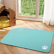Tapis de repas Nidofé Rive turquoise, avec motif de patte, posé sur un sol en bois.