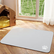 Tapis de repas Nidofé Rive gris clair, avec motif de patte, posé sur un sol en bois.