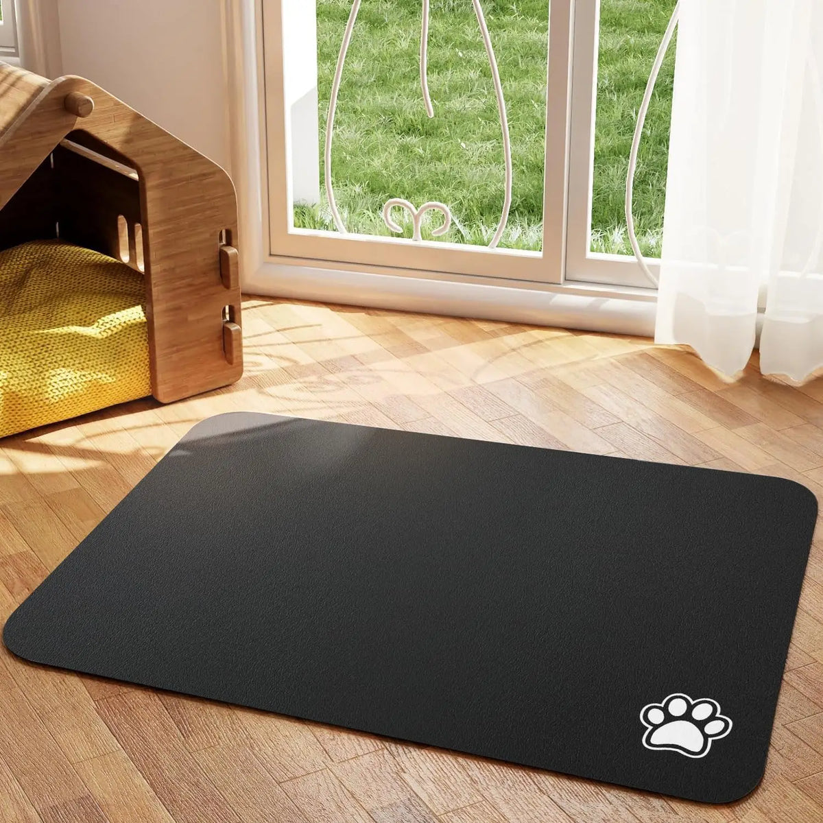 Tapis de repas Nidofé Rive noir, avec motif de patte, posé sur un sol en bois.