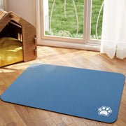 Tapis de repas Nidofé Rive bleu, avec motif de patte, posé sur un sol en bois.