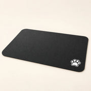 Tapis de gamelles noir à motif patte — vue studio illustrative